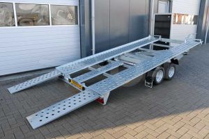 Kantelbare autotransporter Blyss Sonda II, afmeting 400x195cm, bruto laadvermogen 2500kg, laadvloerhoogte 56cm. Achteraanzicht bij gekantelde laadvloer met opgelegde oprijplaten.
