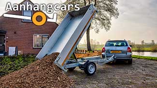 Enkelasser Eduard kipper, gekoppeld aan een peronenauto, met een berg houtsnippers die is gestort.