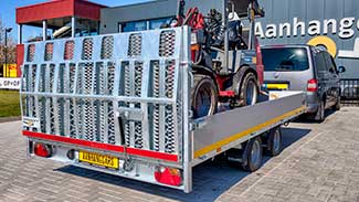 Kantelbare Eduard machinetransporter met brede oprijklep en een kleine graafmachine in de laadbak