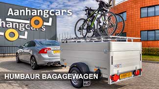 Humbaur aluminium bagagewagen met fietsen op het deksel aangekoppeld achter een personenauto