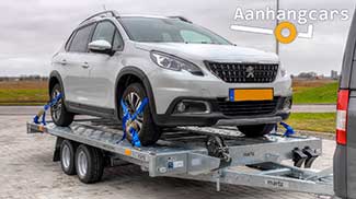 Een kantelbare Martz tandemas autotransporter met rijbanen waar reen personenauto op staat