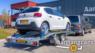 Martz tandemas autotransporter met rijbanen die aan voor- en achterzijde schuin aflopen waarop een kleine auto staat.